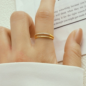 Detailed close-up of a double-layered gold teardrop ring with pavé diamonds on finger