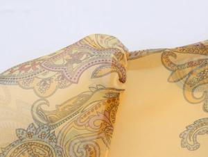 Macro shot of yellow paisley organza fabric showing intricate patterns and texture