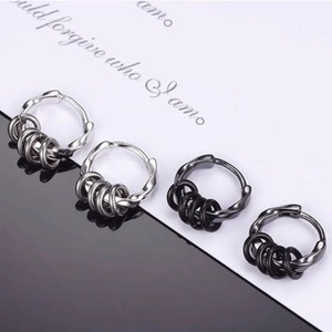 Detail view of silver and black stainless steel hoop earrings with hanging small rings
