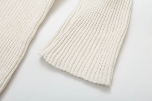 Detailed close-up of ivory ribbed knit cuffs and thick fabric texture on dress