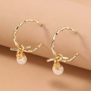 Minimalist gold bamboo hoop earrings with pearls and wire-wrapped knot detail