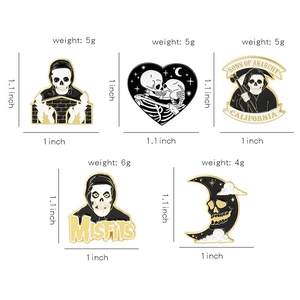 Detail showing Gothic skull and cat enamel pins with dimensions 1 to 1.1 inches