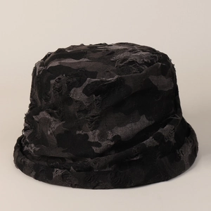 Detailed view of the distressed dark camo bucket hat with torn edges and worn-out texture