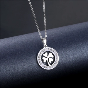 Detail of silver clover pendant with hollow design and white rhinestones on chain