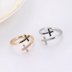 Close-up of elegant cross rings featuring black and white cubic zirconia on copper band