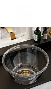 Macro view of thickened transparent PET washbasin showing smooth rim and golden drain plug