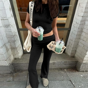 Completo nero da donna con crop top e pantaloni yoga a zampa a vita alta per uso urbano