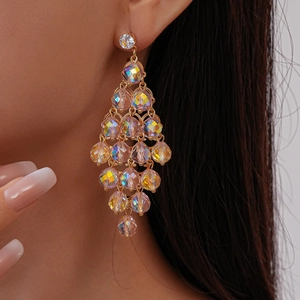Close-up of gold layered crystal rhombus earrings on model for a luxurious fashion look