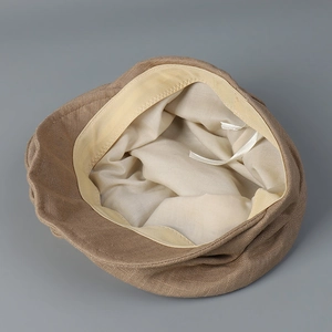 Detail view of khaki newsboy cap interior showing adjustable drawstring and soft lining