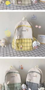 Detail of plaid school backpack with rainbow badge and cute bunny pendant accessory