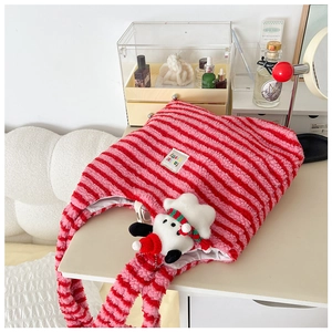 Detail of red and pink striped plush shoulder bag with a cute dog plush keychain charm