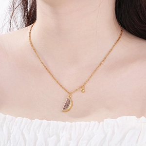 Detail of gold necklace featuring a sparkling crystal-encrusted watermelon slice pendant