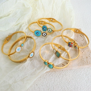 Golden Evil Eye bangle set with turquoise and shell details in a bohemian style