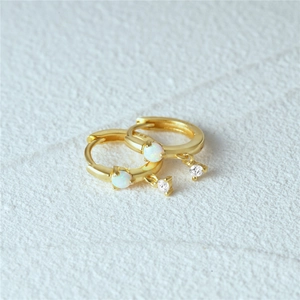 Detail of gold-plated S925 silver hoop earrings with white opal and clear zircon stones
