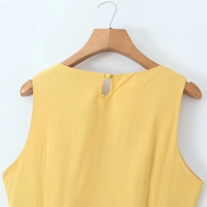 Elegant sleeveless yellow dress with irregular design and button back closure on wooden hanger