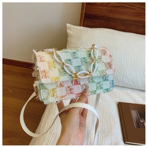 Détail du sac à bandoulière tissé à carreaux colorés avec franges et chaîne en acrylique
