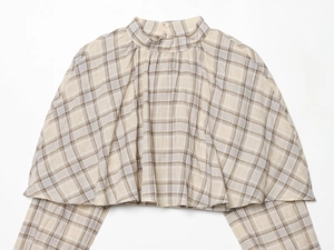 Detail of plaid crop top featuring a high neck with pleated trim and back button closure