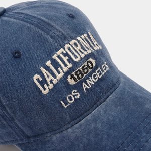 Macro shot of vintage blue denim baseball cap with intricate California embroidery
