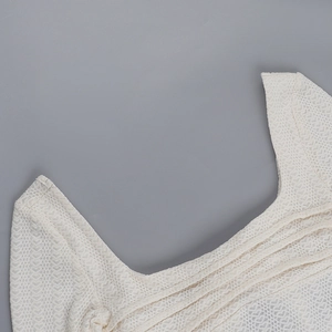 Gros plan détaillé sur la texture en dentelle blanche et la coupe de l'encolure du haut