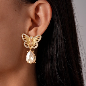 Detail of hollow butterfly drop earring with champagne gemstones and zircon accents