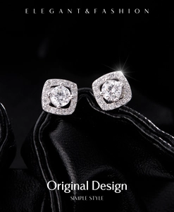 Macro shot of silver square halo earrings with shimmering crystals on black leather