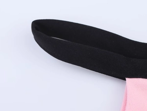 Dettaglio del tessuto a maglia rosa con spalline elastiche nere e trama di precisione