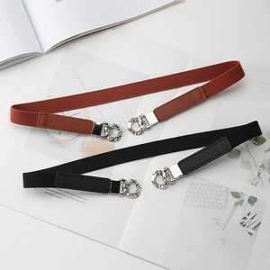 Detail of black and brown elastic waist belts with silver metal interlocking buckles