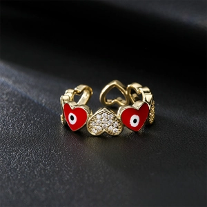 Golden evil eye heart ring with red enamel and sparkling zircons in adjustable open style