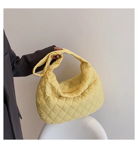 Detailed shot of yellow quilted cloud bag featuring nylon material and large capacity