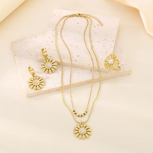 Golden sunflower jewelry set including double-layered necklace, earrings and ring on stone