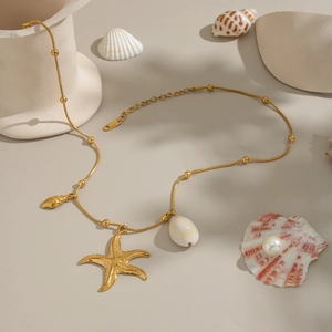 Golden ocean theme necklace featuring a large starfish pendant and natural shell accents