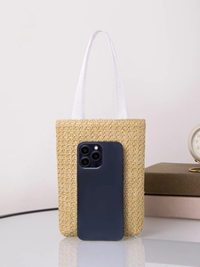 Mini straw tote bag in natural beige with white woven handles and smartphone scale comparison