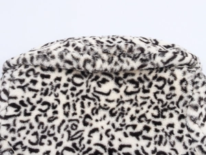 Close-up of fluffy faux fur texture with black and white leopard pattern on the coat