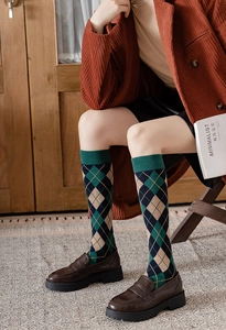 Close-up of Argyle pattern knee-high socks in navy and green with vintage leather shoes