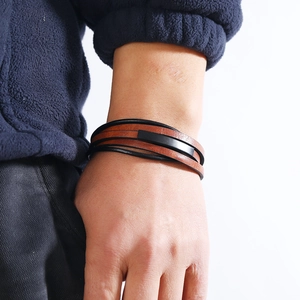 Detail of multilayer woven leather bracelet with magnetic clasp on man's wrist