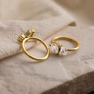 Macro shot of gold-plated rings with pear and marquise-cut white zircons in claw setting