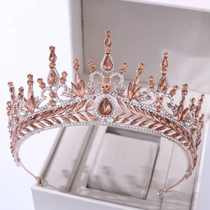 Close-up of rose gold bridal crown with champagne crystals and leaf patterns in a jewelry box