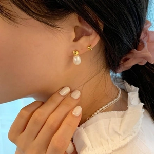Detailed view of elegant S925 silver water drop pearl earrings worn by a female model