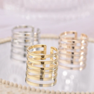 Close-up of multilayered open titanium steel rings in gold and silver with a polished finish