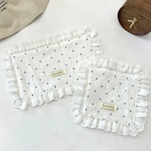 Detail of white cotton lace placemats with blue heart patterns and Sonakka tag