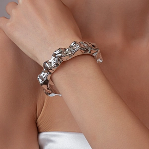 Macro detail of silver irregular lava texture bracelet with a liquid metal mirror finish