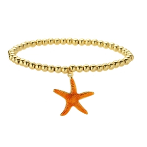 Detail of golden beaded bracelet featuring a vibrant orange starfish charm on white background