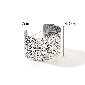 Detailed macro view showing the embossed floral patterns on this vintage silver wide cuff bracelet