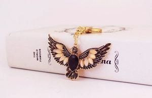 Detail of vintage eagle keychain with rhinestones and black gemstones on a book
