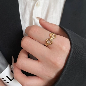 Macro shot of 18K gold-plated double-loop link ring on a hand with elegant office attire