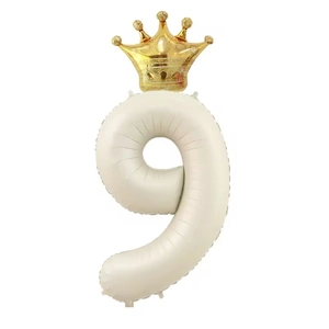Detail of cream number 9 balloon with gold crown for birthday party decor