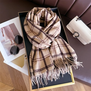 Detail of soft beige and brown plaid cashmere-like scarf with fringe on a tray