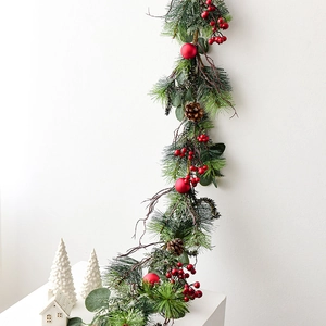 Christmas garland with red berries and pine cones on a table for holiday home decor