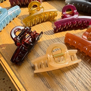 Flat lay of colorful resin shark hair claws on a rustic wooden texture background