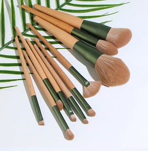 Detailed overhead view of 12 makeup brushes with wood handles and green aluminum tubes